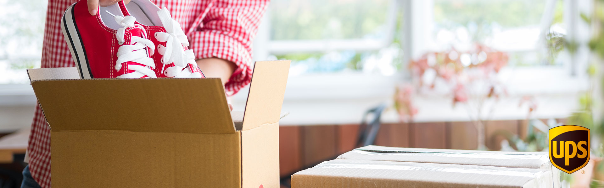 Corriere UPS Una ragazza inscatola delle scarpe da spedire con un corriere ups